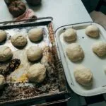 Kulki domowego ciasta drożdżowego rosnące na rustykalnych blaszkach