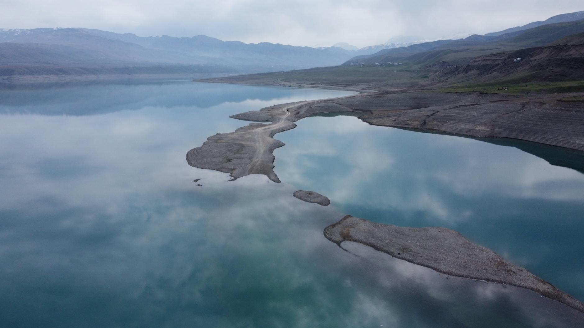 Malownicze jezioro w Papani w Kirgistanie z odbiciem pochmurnego nieba