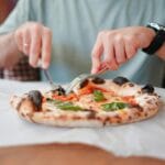 Mężczyzna je kolorową pizzę w włoskiej restauracji w Trójmieście