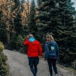 Para na zimowym spacerze leśnym szlakiem wśród ośnieżonych drzew