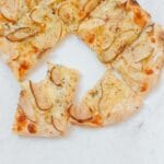 Pizza z gruszką i serem na cienkim cieście pokrojona na kawałki