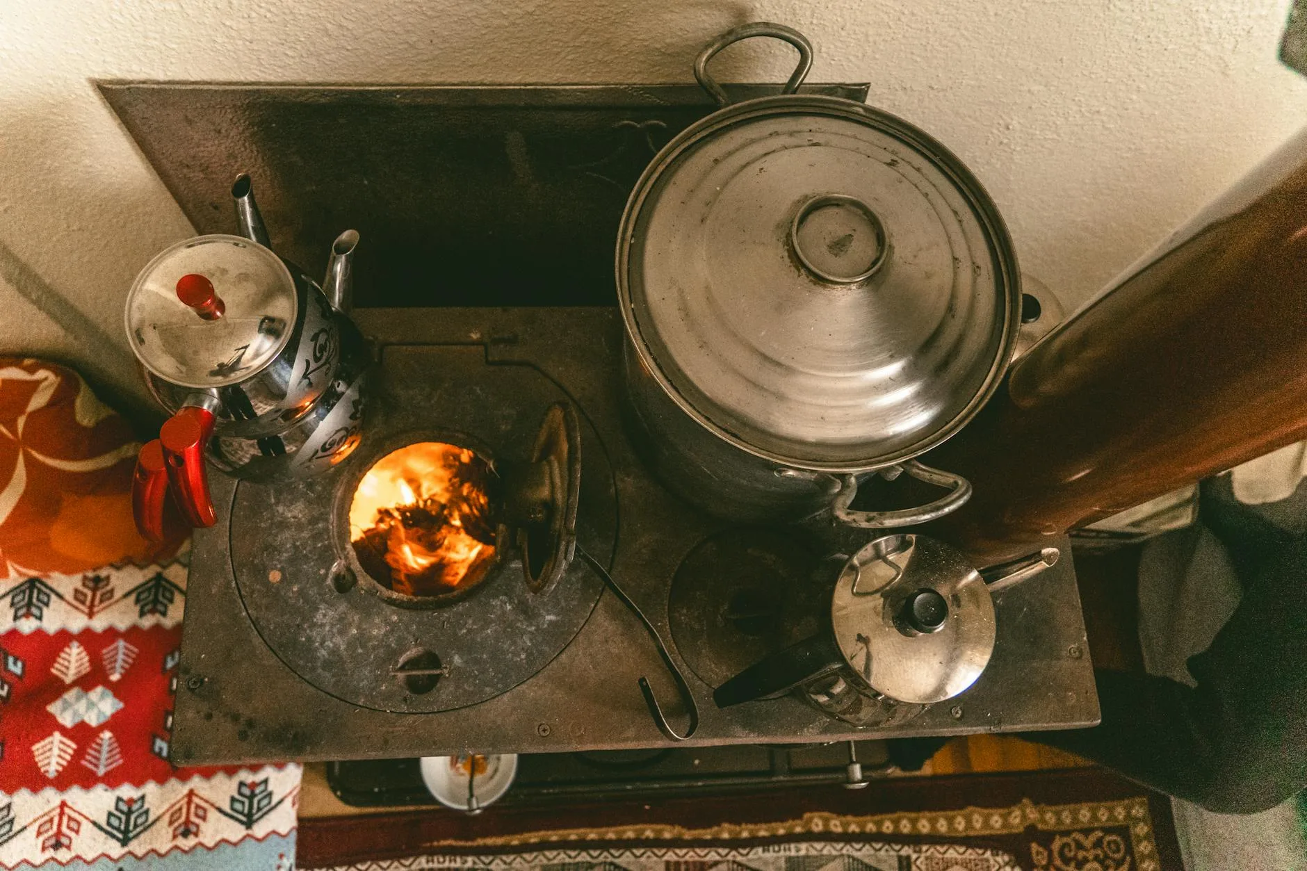 Stary piec kuchenny z garnkami i czajnikami w przytulnym wnętrzu