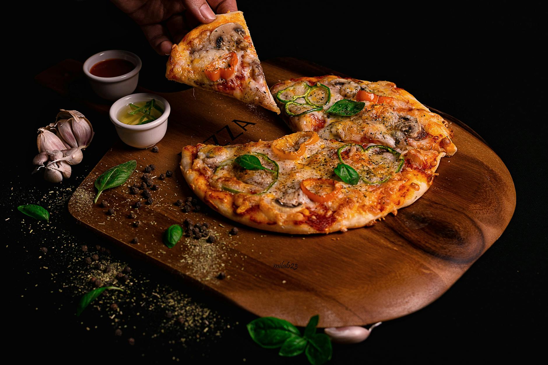 Kawałek pizzy z warzywami i ziołami na drewnianej desce