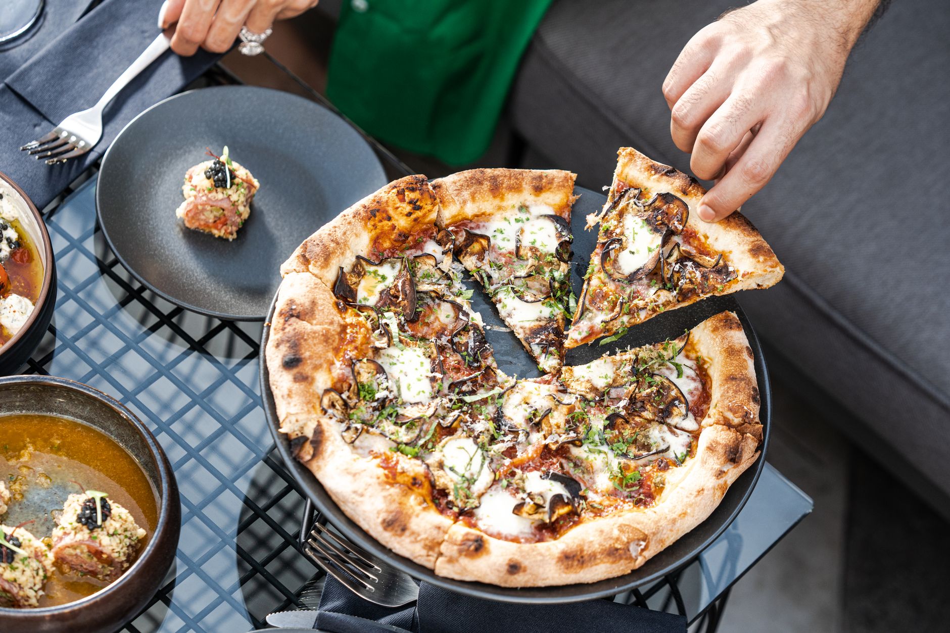 Pizza z truflą: recenzja pizzerii, która obiecuje luksus na cieście Gourmet pizza z pieczarkami, ziołami i mozzarellą na stole w Dubaju